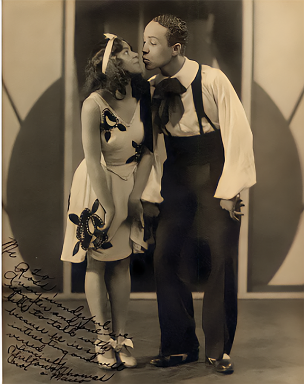 photo of a couple posing together with an illegible handwritten dedication in the corner.